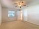 Bedroom with carpet, a ceiling fan, and a window, offering a bright and airy feel at 832 Wildwood Cir, Port Orange, FL 32127