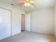 Bedroom with carpet, white walls, ceiling fan, closet, and a door to another room at 832 Wildwood Cir, Port Orange, FL 32127