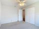 Carpeted bedroom with a closet, ceiling fan and door creating a bright and airy feel at 832 Wildwood Cir, Port Orange, FL 32127