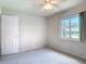 Neutral bedroom with a ceiling fan, window with view and closet door at 832 Wildwood Cir, Port Orange, FL 32127