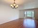 Dining room with chandelier lighting, hardwood flooring, neutral walls, and a bay window at 832 Wildwood Cir, Port Orange, FL 32127