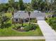 Aerial view showcases the home's well-maintained front yard, fresh landscaping, and a long driveway for ample parking at 832 Wildwood Cir, Port Orange, FL 32127