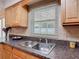 Kitchen sink with stainless steel faucet, and mosaic backsplash set under a bright window at 832 Wildwood Cir, Port Orange, FL 32127