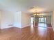 Living room with hardwood flooring, mirrored wall, and an open view into another room at 832 Wildwood Cir, Port Orange, FL 32127