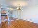 Light-filled room featuring hardwood floors, mirrored wall, and an open view into the kitchen at 832 Wildwood Cir, Port Orange, FL 32127