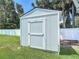 Close-up of a small white shed in the backyard, next to a white vinyl fence at 832 Wildwood Cir, Port Orange, FL 32127
