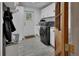 This is a laundry room with gray tile floors, white cabinets, and a front load washer at 851 W Wisconsin Ave, Orange City, FL 32763