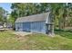 Outbuilding with double doors and a covered side porch for additional storage at 851 W Wisconsin Ave, Orange City, FL 32763