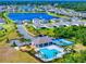 Aerial view of community amenities including pool, playground, sports courts and nearby lake at 918 Noble Run, New Smyrna Beach, FL 32168