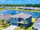 Aerial view showing a two story home with a two car garage, front yard landscaping and view of the lake at 918 Noble Run, New Smyrna Beach, FL 32168