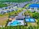 Community aerial view showcases a pool, playground, sports courts, and lush surroundings at 918 Noble Run, New Smyrna Beach, FL 32168