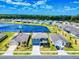 Aerial view of homes with a lake and fountain surrounded by lush green lawns and mature trees at 918 Noble Run, New Smyrna Beach, FL 32168