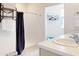 Bright bathroom with shower behind a curtain, open shelving and doorway to walk-in closet at 918 Noble Run, New Smyrna Beach, FL 32168
