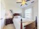 Cozy bedroom with a dark wood bed frame, ceiling fan, carpet, and a bright window, creating a relaxing retreat at 918 Noble Run, New Smyrna Beach, FL 32168