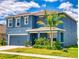 Lovely two-story home featuring light blue siding, a manicured lawn, and mature landscaping at 918 Noble Run, New Smyrna Beach, FL 32168