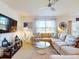 Spacious living room with cozy furniture, modern decor, a large flat screen TV, and sliding glass doors at 918 Noble Run, New Smyrna Beach, FL 32168