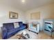 Comfortable living room featuring a blue sofa, accent chair, glass table, and stylish decor at 918 Noble Run, New Smyrna Beach, FL 32168