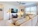 Comfortable living room featuring a plush sectional sofa, large windows, and a ceiling fan for ample natural light at 918 Noble Run, New Smyrna Beach, FL 32168