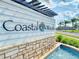 Coastal Woods community sign featuring a water fountain and stone facade at 918 Noble Run, New Smyrna Beach, FL 32168