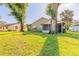 Exterior view of home, back of home, and screen-in porch from yard with trees at 929 N Lakewood Ter, Port Orange, FL 32127