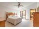 Bright bedroom featuring a ceiling fan, sliding glass doors, and an attached bathroom entrance at 929 N Lakewood Ter, Port Orange, FL 32127