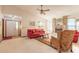Welcoming living room featuring a red sofa, a ceiling fan and a large brick fireplace at 929 N Lakewood Ter, Port Orange, FL 32127
