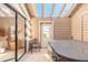 Enclosed sunroom with hot tub, tiled floor, sliding glass doors to bedroom and exit door at 929 N Lakewood Ter, Port Orange, FL 32127