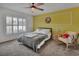 Cozy bedroom featuring natural light, a ceiling fan, and bright yellow accent wall at 953 Tulip St, Deltona, FL 32725