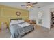 Bedroom with a ceiling fan and en-suite bathroom access and bright yellow accent wall at 953 Tulip St, Deltona, FL 32725