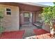 Charming covered porch features a bench, brick accents, and well manicured landscaping elements at 953 Tulip St, Deltona, FL 32725