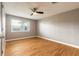 Bright bedroom with hardwood floors, neutral walls, a ceiling fan, and a window with blinds for natural light at 1032 Bel Aire Dr, Daytona Beach, FL 32118