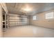 An empty spacious garage with a working garage door and windows for lighting at 1032 Bel Aire Dr, Daytona Beach, FL 32118