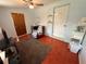 Bedroom featuring a red cushioned chair, shelving, and red stained floors at 1081 Cobblestone Ave, Deltona, FL 32725