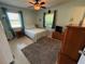 Cozy bedroom features ceiling fan, two windows with curtains, and neutral walls and carpet at 1081 Cobblestone Ave, Deltona, FL 32725