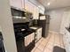 Efficient kitchen featuring white cabinets, black appliances, and tile floors, offering a practical cooking space at 1081 Cobblestone Ave, Deltona, FL 32725