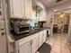 Traditional kitchen features white cabinets, stainless steel appliances, and tile flooring at 1081 Cobblestone Ave, Deltona, FL 32725