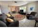 Inviting living room featuring a plush gray sofa, recliner, tile floors, and a decorative rug at 1081 Cobblestone Ave, Deltona, FL 32725