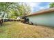 Expansive backyard with mature trees and a covered patio area, perfect for outdoor gatherings at 1113 Fort Smith Blvd, Deltona, FL 32725