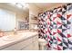 Bathroom featuring a patterned shower curtain, toilet and single sink vanity with shelving at 1113 Fort Smith Blvd, Deltona, FL 32725
