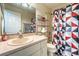 Bathroom featuring a patterned shower curtain, toilet and single sink vanity with shelving at 1113 Fort Smith Blvd, Deltona, FL 32725