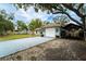 Charming single-story home with a white garage door and covered parking area, nestled under mature trees and blue skies at 1113 Fort Smith Blvd, Deltona, FL 32725