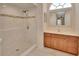 Bathroom featuring tiled walk-in shower, vanity, and decorative mirror at 1142 Glendale Ave, Deltona, FL 32725