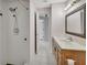 Bathroom with shower, vanity with wood cabinets, and framed mirror at 1142 Glendale Ave, Deltona, FL 32725
