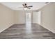 Bedroom with ceiling fan, door to sunroom, neutral walls, and gray wood flooring at 1142 Glendale Ave, Deltona, FL 32725