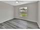 Bedroom with gray wood flooring and a window overlooking the backyard at 1142 Glendale Ave, Deltona, FL 32725