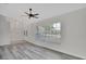 Spacious living room featuring gray wood floors, a large window and entry doors with decorative glass at 1142 Glendale Ave, Deltona, FL 32725