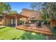 Backyard patio area for entertaining with outdoor seating, artificial turf, and landscaped features at 115 Oaks Ct # 115, Sanford, FL 32771