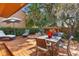 Backyard patio area for entertaining with outdoor seating, fire pit, lush landscape features and an umbrella at 115 Oaks Ct # 115, Sanford, FL 32771