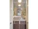 Compact bar area with mosaic tile, mirrored backsplash, glass shelving, and storage nestled between bright white louvered doors at 115 Oaks Ct # 115, Sanford, FL 32771