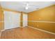 Bright bedroom featuring wood floors, a ceiling fan, and a spacious closet with folding doors at 115 Oaks Ct # 115, Sanford, FL 32771